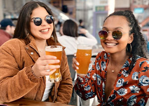 Two friends drinking beer pints