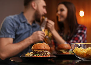 Couple enjoying a meal with a burger in the foreground