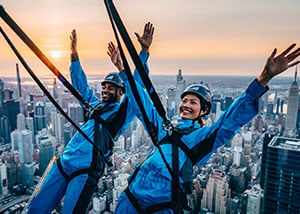 Two people leaning out over the EDGE in New York