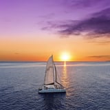 Boat sailing at sunset