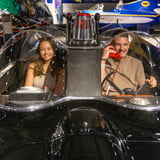 Two people sitting in Batmobile
