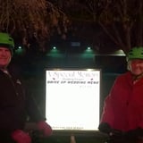 Two people in front of sign