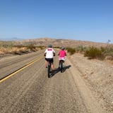 Two people riding bikes on road