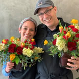 Two people with flower arrangements