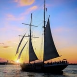 Ship sailing at sunset