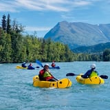 Group of Rafters on Water with Mountain View