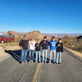 Group Posing in Front of Scenic Desert 