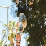 Two people holding hands on trapeze