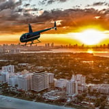 Helicopter In Sky Over City at Sunset