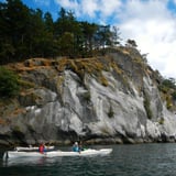 Group kayaking near rock