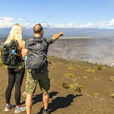 Two people pointing at volcano
