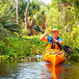 Woman kayaking through marsh