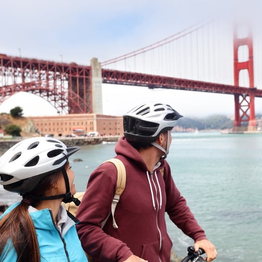 Couple on Bikes in Front of Golden Gate Bridge