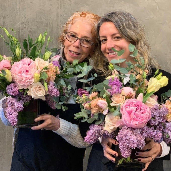 Two woman with flower arrangements