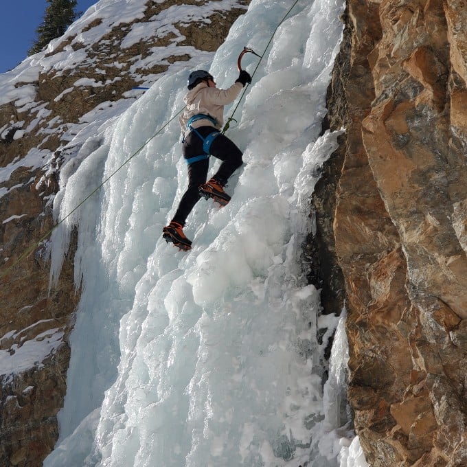 Person climbing on ice covered rock