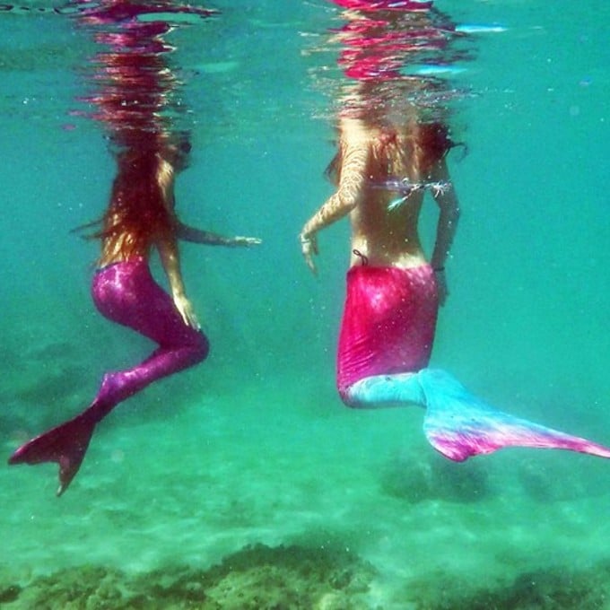 Two mermaids in water