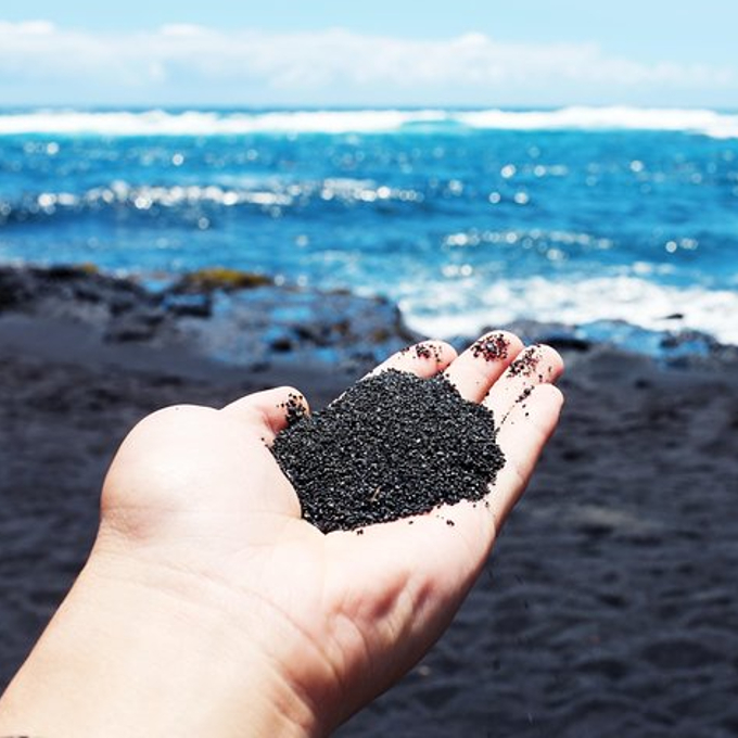 Person holding black sand