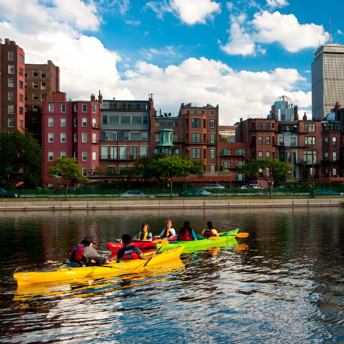 People kayaking along city