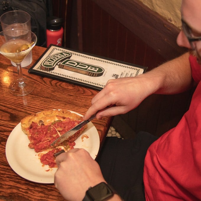 Person Cutting Deep Dish Pizza