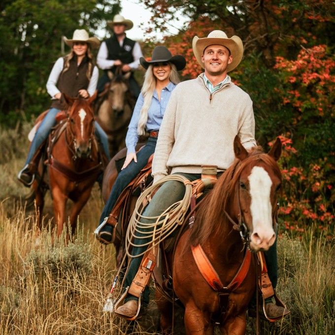 Group riding down hill on horses