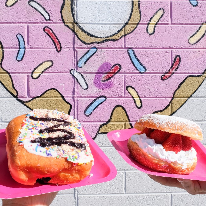 Two donuts in front of donut art