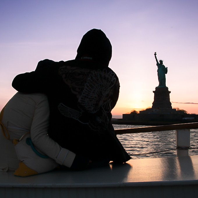 Couple viewing Statue of Liberty at sunset