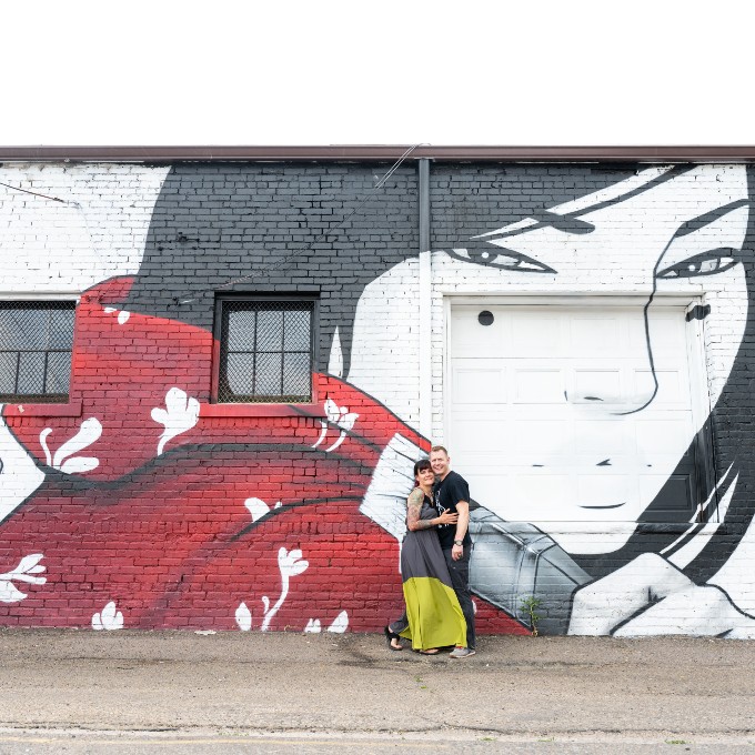 Couple posing in front of wall art