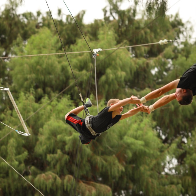 Two people connecting on trapeze