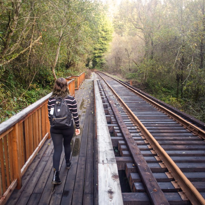 Woman Hiking Across Rail Tracks
