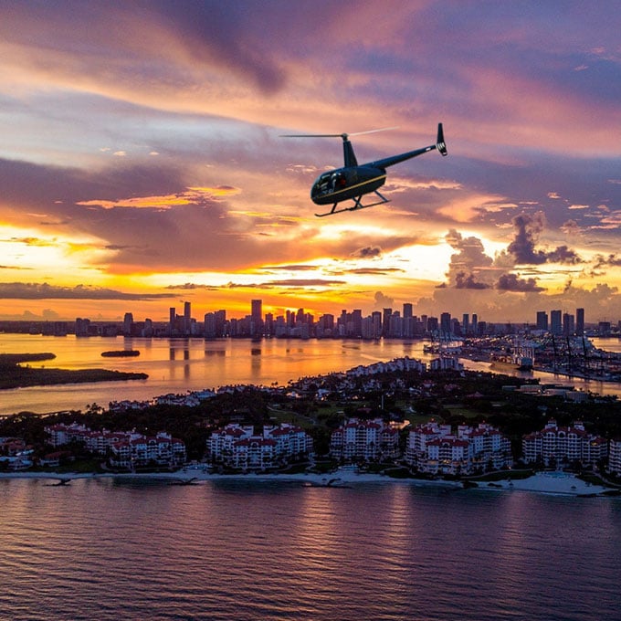 Helicopter Over Water at Sunset with Skyline Background