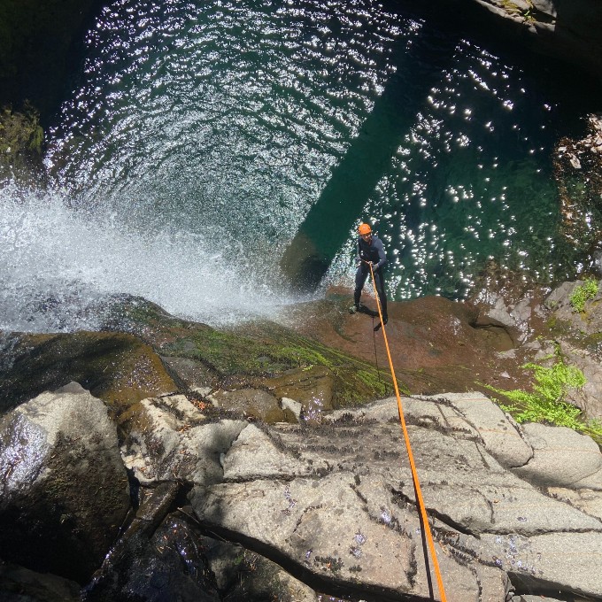 Man repelling down waterfall